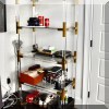 F25. Lucite shelf with brass bracings. 66”h x 30”w x 16”d 